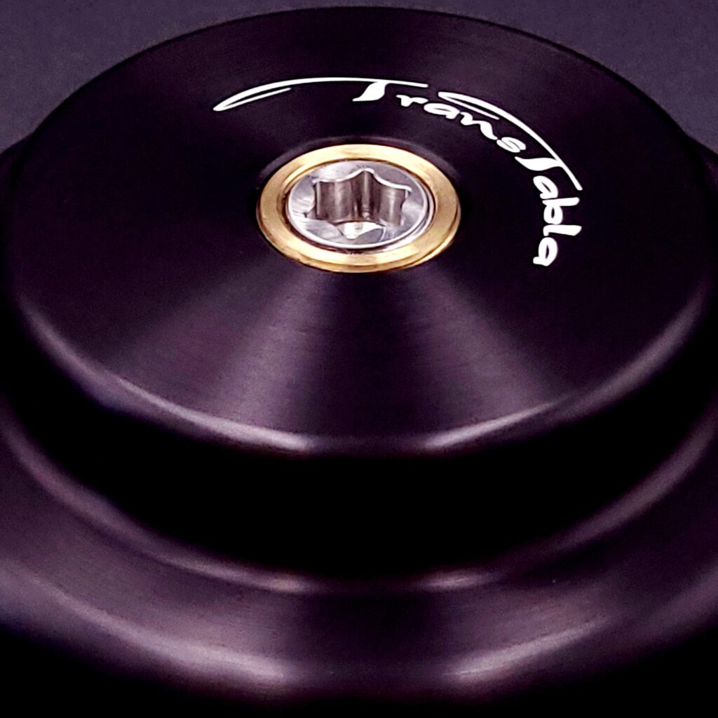 Close-up of a black and gold component with 'TransTabla' branding on a dark background